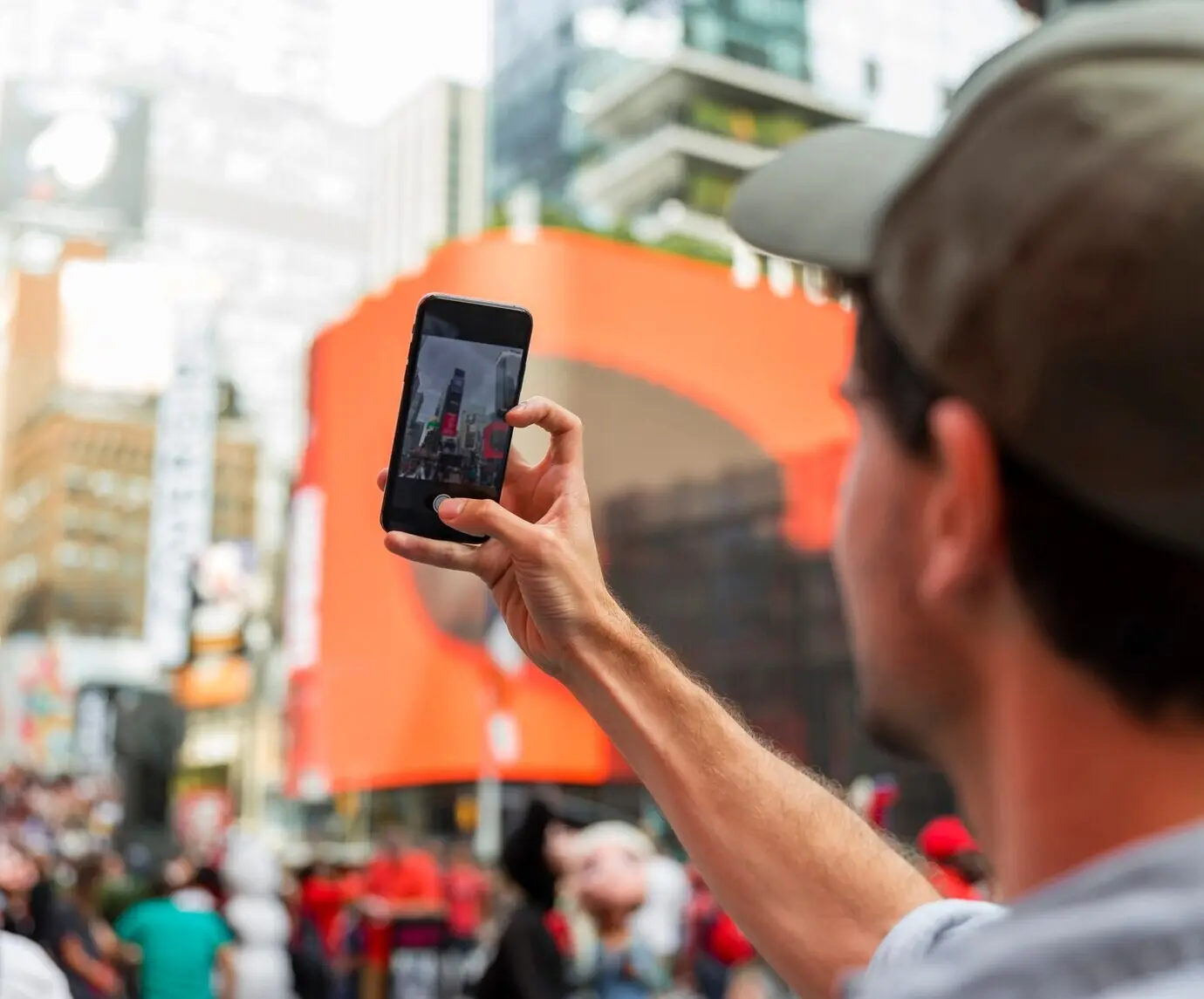Rostro borroso de un hombre tomándose una selfie en la ciudad.